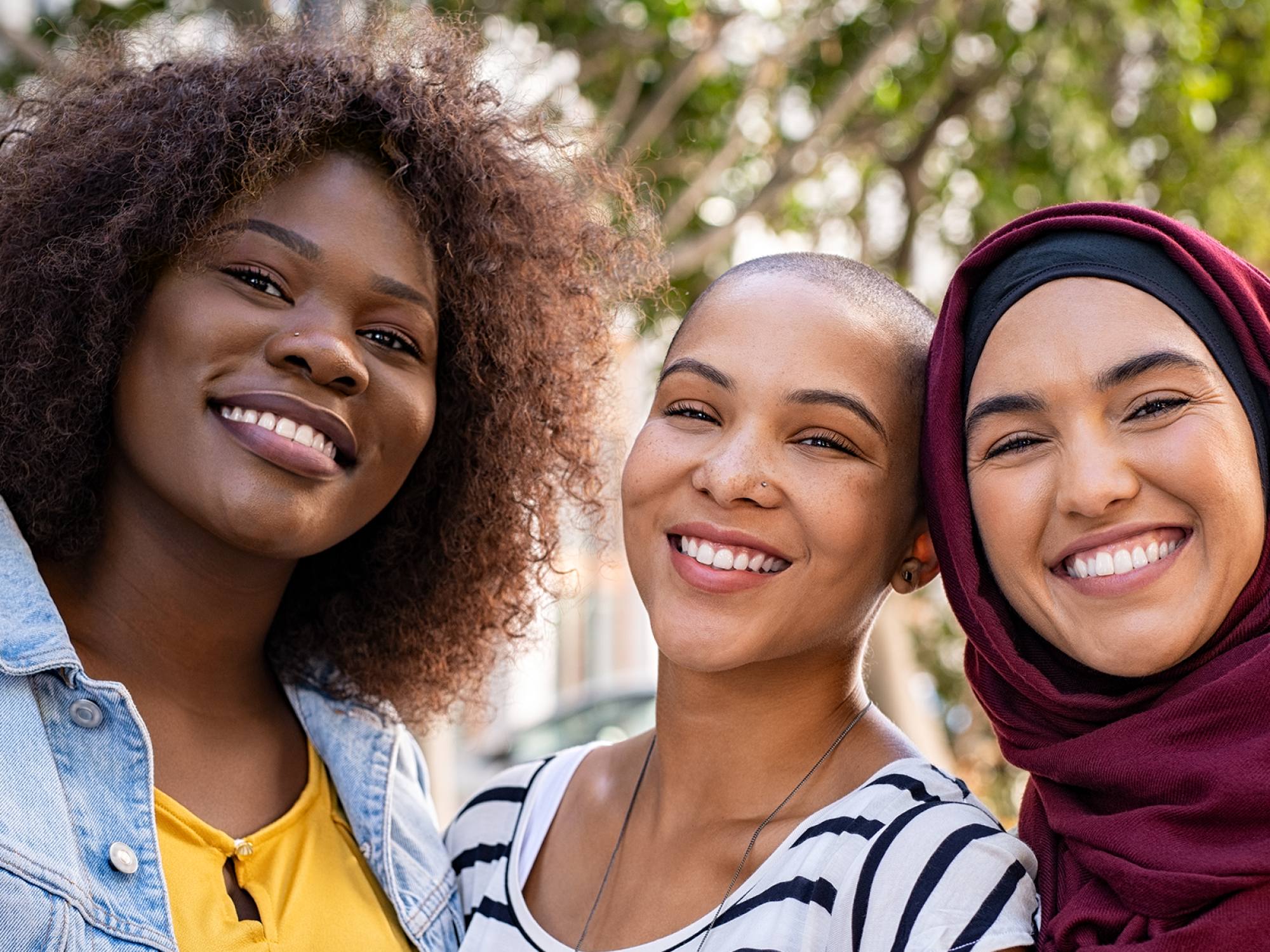 Three women smiling at the camera 